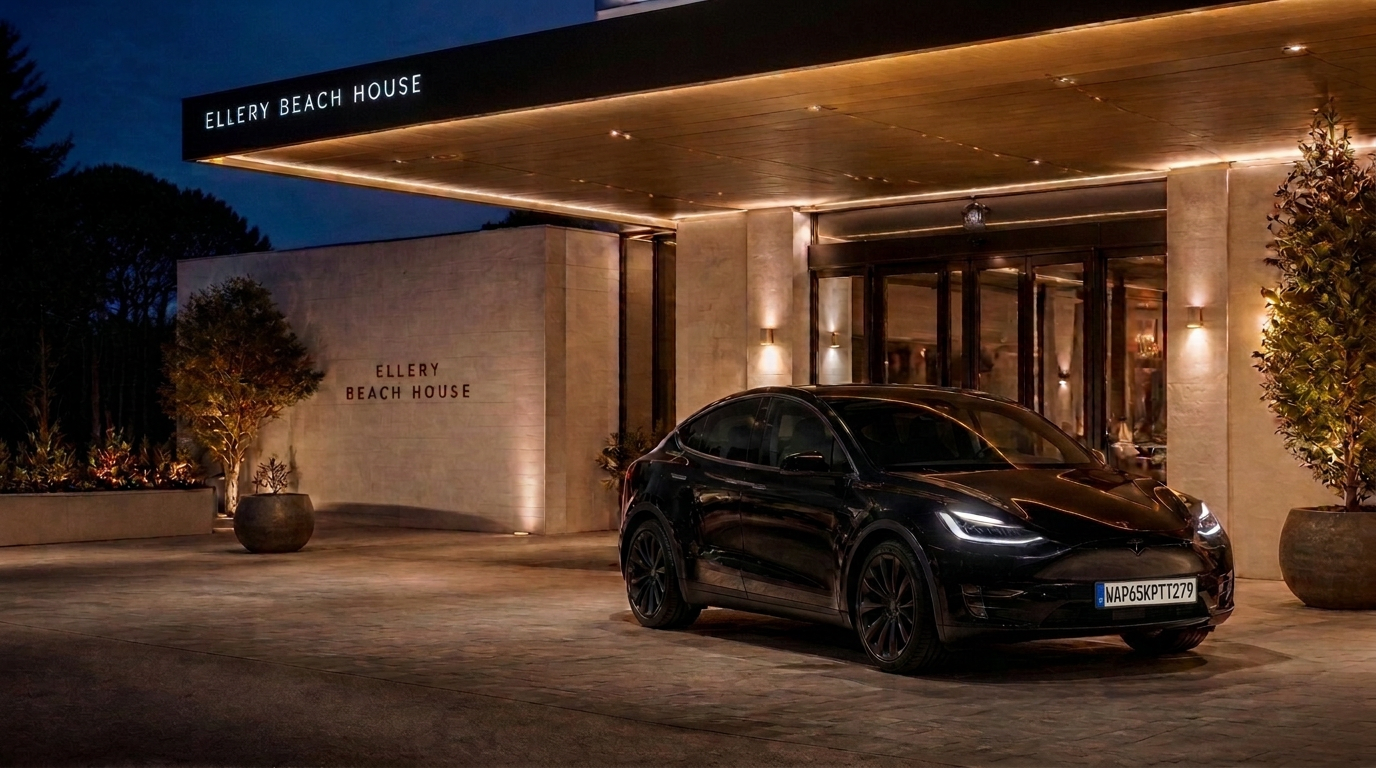 Black Tesla Model Y at the entrance of a modern Scandinavian luxury hotel